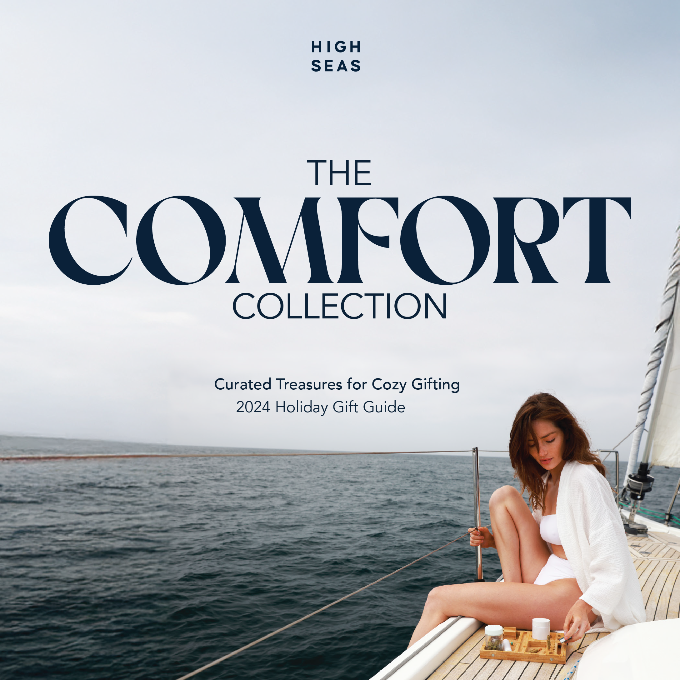 Woman on sailboat with tea set, wearing white robe. Text reads The Comfort Collection, Holiday 2024.